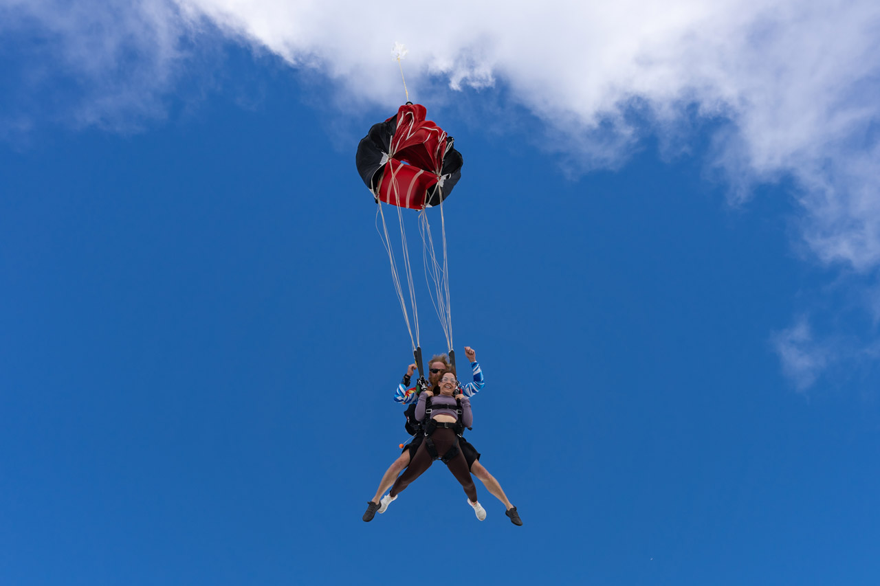 Tandem skydiving student and instructor release canopy after freefall