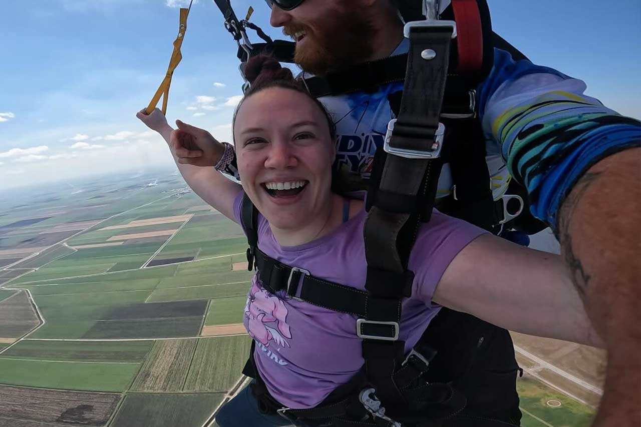 Female tandem skydiver with her instructor under canopy