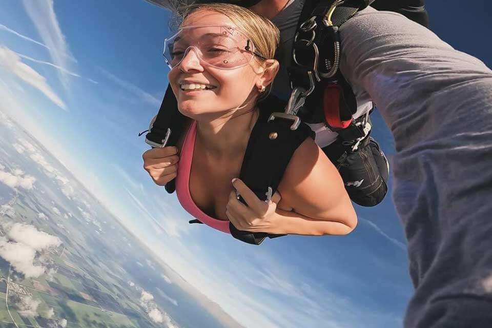 Female tandem student in skydiving freefall with her instructor