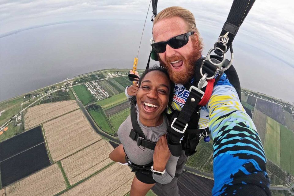 Tandem instructor and her instructor smiling under canopy