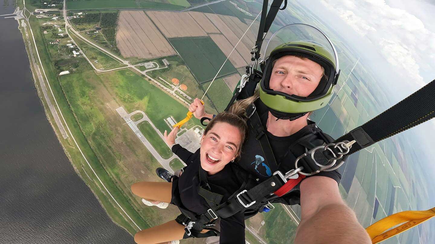 male and female tandem skydiving pair under canopy