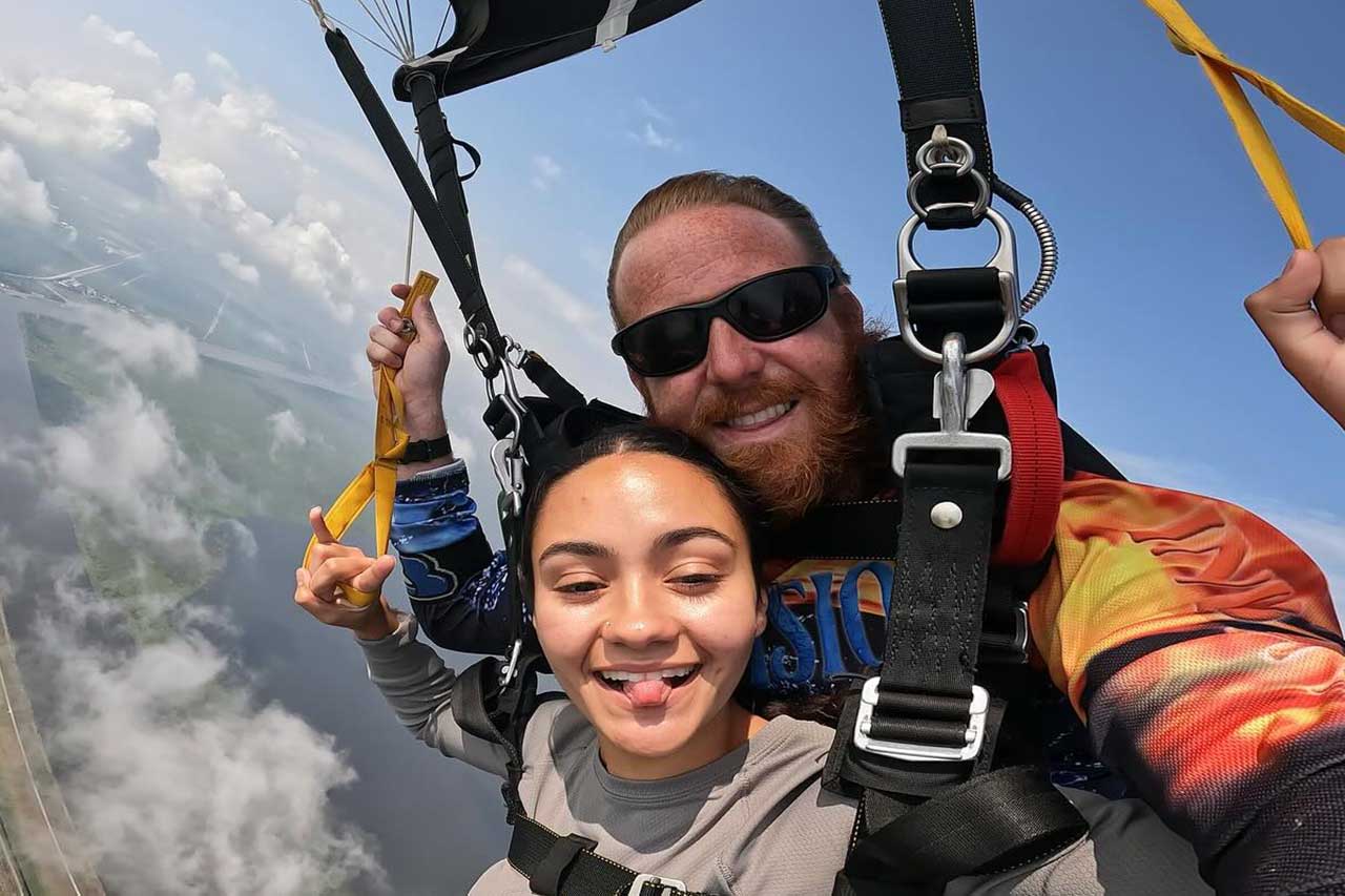 Female tandem skydiver with her instructor under canopy