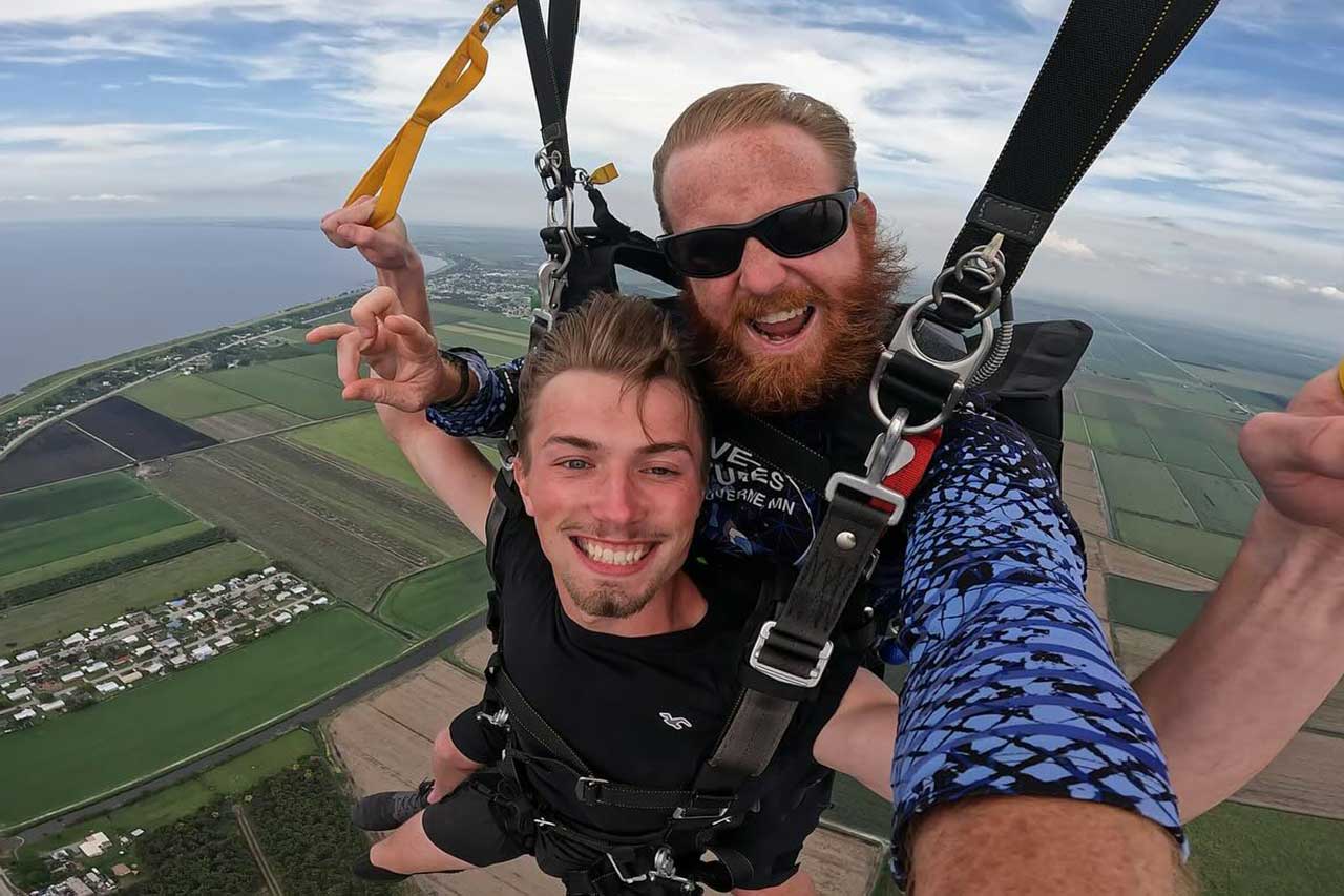 Male tandem skydiving pair under canopy with a beautiful view at Skydive Palm Beach.