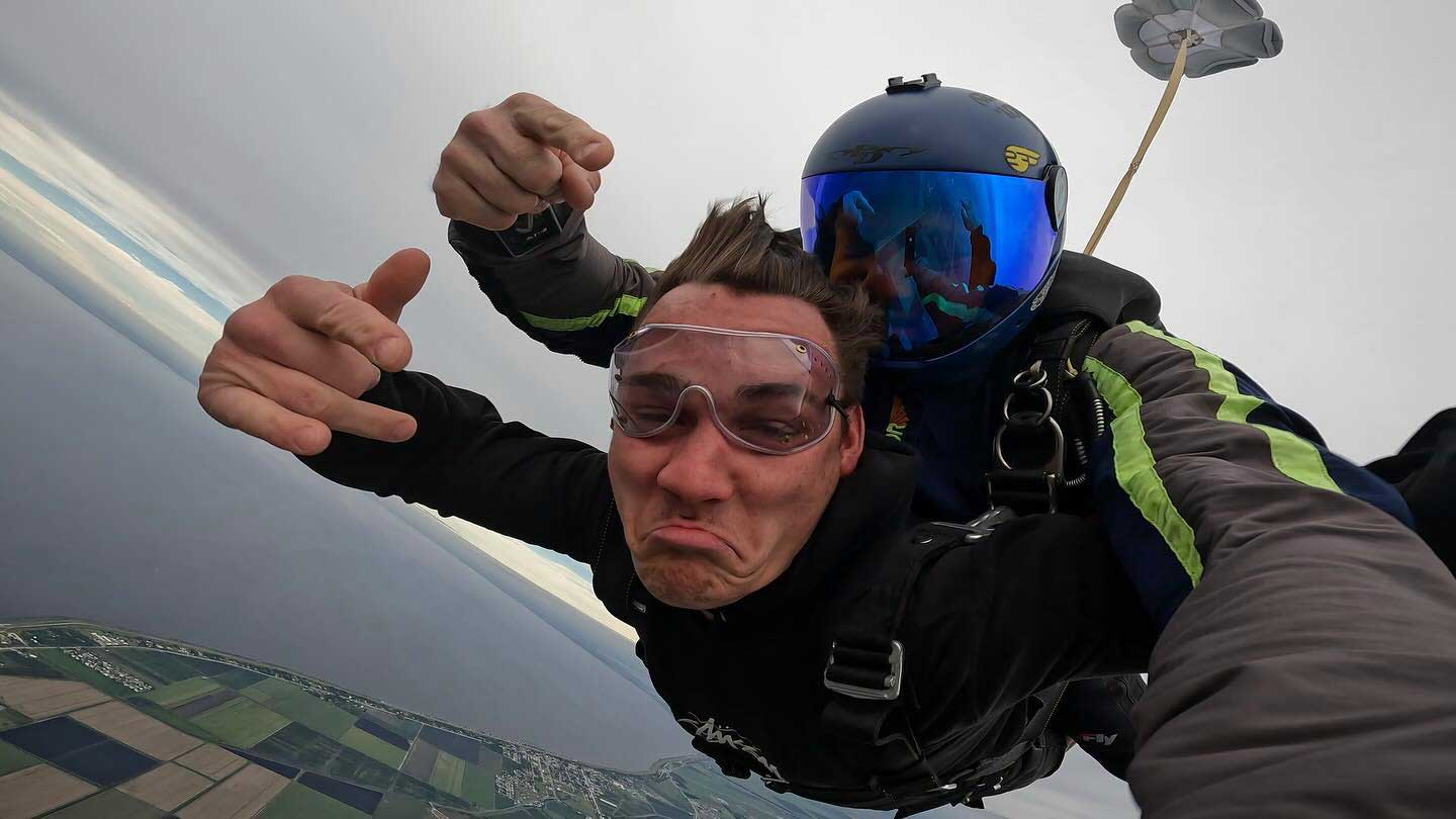 male tandem skydiver makes funny face in freefall