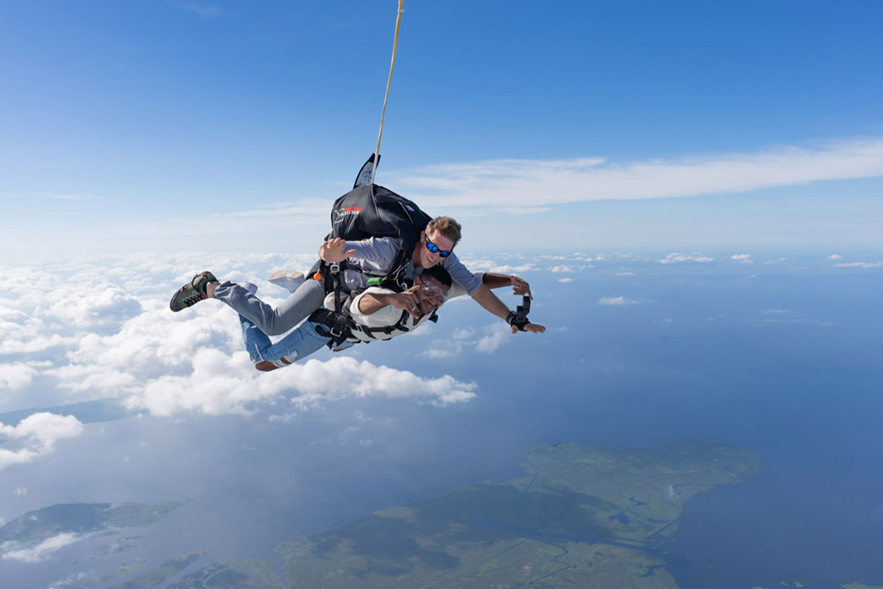 Side view of tandem skydiving student and instructor in freefall